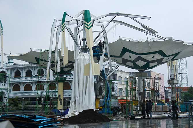 RUSAK LAGI: Kondisi payung madinah yang kembali rusak saat pekerja melakukan uji coba, Senin sore (19/12). (Mokhamad Zubaidillah/ Radar Bromo)