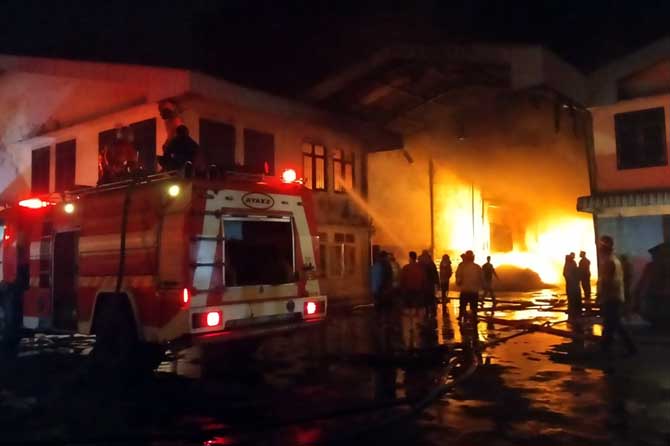 Petugas saat memadamkan kobarna api di pabrik sandal Evarindo di Ngerong, Gempol.