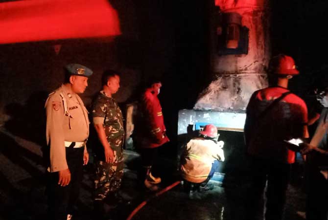 Petugas damkar saat melakukan pembasahan di pabrik karoseri yang sudah lama tak beroperasi.