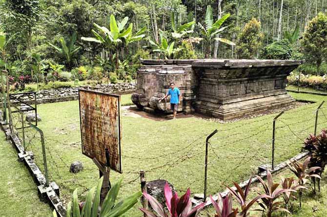 MASIH KOKOH: Juru Pelihara (jupel) Candi Kedaton Niman (baju biru) menunjukkan beberapa arca candi. (Foto: Achmad Arianto/Jawa Pos Radar Bromo)