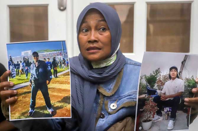 TINGGAL KENANGAN : Rini Hanifah, ibu dari korban Agus Ariansyah menunjukkan foto Almarhum semasa hidupnya saat hadir pada sidang perdana kasus tragedi Kanjuruhan Malang yang digelar di Pengadilan Negeri Surabaya (16/1)  Sidang dengan agenda pembacaan dakw