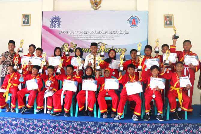 MEMBANGGAKAN: 18 siswa-siswi SD AL Kautsar yang meraih Kejuaraan Pencak Silat Jember Nasional Championship di Jember didampingi oleh Kepala SD Al Kautsar Mustakin, S.PdI, S.Pd. (tengah). (Foto: Erri Kartika/Jawa Pos Radar Bromo)