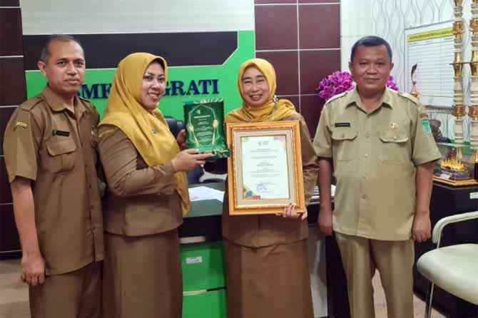 KANTIN BERSIH: Kepala sekolah SMKN 1 Grati, Dra. Nining Faridah, M.Si (kedua dari kanan) ketika menerima penghargaan sentra pangan jajanan/kantin. (Foto: Istimewa)