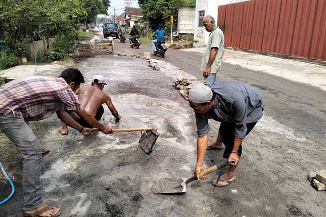 SWADAYA: Warga swadaya memperbaiki jalan rusak di Dusun Begagah, Desa Kemirisewu, Kecamatan Pandaan. (Foto: Rizal F. Syatori/Jawa Pos Radar Bromo)