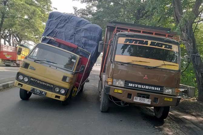 Kondisi salah satu truk yang miring hendak terguling saat melintas di jalan Bypass Gempol yang miring. (Rizal Syatori/Radar Bromo)