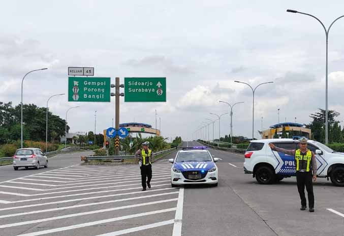 REKAYASA: Petugas Satlantas Polres Pasuruan menutup sementara ruas jalan tol Gempol menuju Kejapanan karena sedang dilakukan contra flow arus lalin dari arah Sidoarjo ke Gempol, Selasa (7/2). (Foto: Rizal F Syatori/Jawa Pos Radar Bromo)