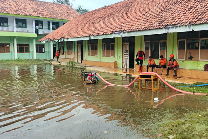 SEDOT: Tim dari BPBD Kota Probolinggo menyedot air yang menggenangi halaman Pesantren Asulthon, Kelurahan Triwung Kidul, Kecamatan Kademangan, Kota Probolinggo, (13/2). (Arif Mashudi/Jawa Pos Radar Bromo)