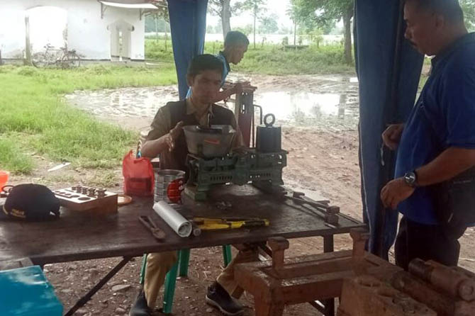 DIUKUR: Salah seorang petugas mengecek timbangan milik pedagang di Pasar Kotaanyar, Kabupaten Probolinggo. (DKUPP for Radar Bromo)