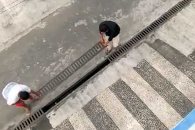 Pelaku dan ayahnya saat mengembalikan besi penutup drainase yang sempat dicuri. (Screenshoot)