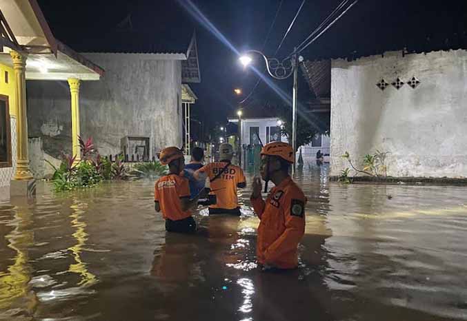DATANGI LOKASI: Anggota BPBD Kota Pasuruan menelusuri area banjir di Dusun Rujak Gadung Kamis (17/2) malam. (Foto: BPBD Kota Pasuruan for Jawa Pos Radar Bromo)