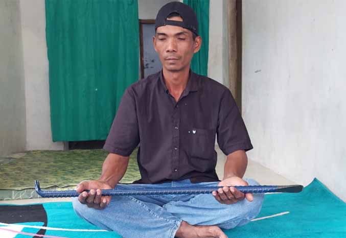 PUNYA FILOSOFI: Mukmin menunjukkan linggis yang jadi mahar nikahnya. (Foto: Rizky Putra Dinasti/Jawa Pos Radar Bromo)