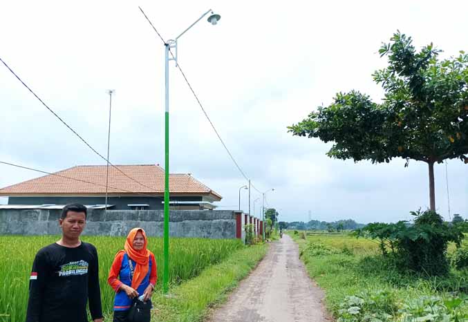 LEBIH NYAMAN: Bendahara Desa Ganting Kulon Arbuati (kanan) mengecek hasil pembangunan PJU. (Foto: Agus Faiz Musleh/Jawa Pos Radar Bromo)