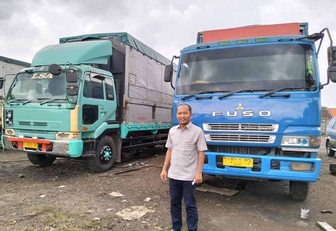 PENGUSAHA TRANSPORTER: Nurul Huda dengan unit truk miliknya. (Foto: Rizal F Syatori/Jawa Pos Radar Bromo)