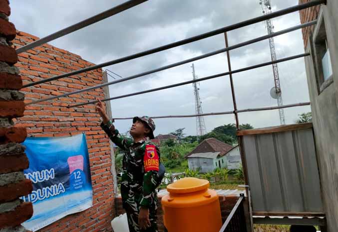 LIHAT KONDISI: Petugas Babinsa mengecek kerusakan bangunan akibat puting beliung di Desa Sekarmojo dan Sengonagung, Rabu (15/2). (Foto: Rizal F Syatori/Jawa Pos Radar Bromo)