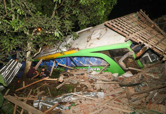 APES: Bus yang menabrak musala dan rumah di Watuagung, Prigen, Selasa (14/2) sore. (Foto: M Zubaidillah/Jawa Pos Radar Bromo)