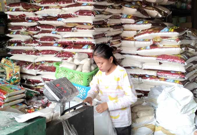 BELANJA: Warga berbelanja beras di toko beras di Pasar Dringu. Permintaan beras Bulog masih tinggi, namun stok yang ada saat ini masih aman. (Foto : Achmad Arianto/Jawa Pos Radar Bromo)