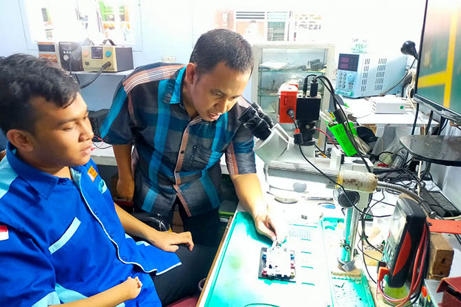 Muhammad Isjudin saat memberikan pelatihan ke salah satu disabilitas di ruang kerjanya. (Iwan Andrik/Radar Bromo)