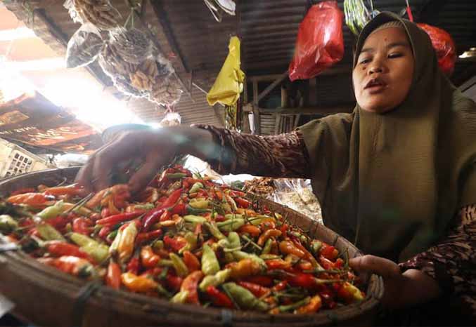 NAIK DRASTIS: Pedagang cabai rawit di Pasar Besar Kota Pasuruan menyiasati kenaikan harga cabai dengan mengurangi jumlah kulakan. (Foto: M Zubaidillah/Jawa Pos Radar Bromo)