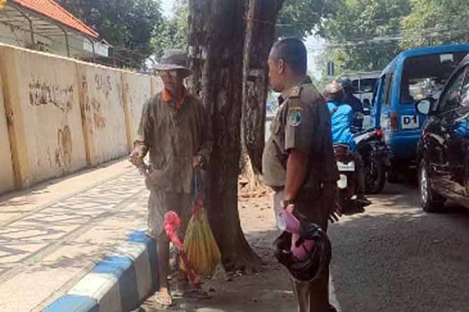 NYAMANKAN KOTA: Anggota Satpol PP Kota Pasuruan menanyai orang yang diduga mengalami gangguan jiwa Senin (20/3). (Foto: Satpol PP Pasuruan Kota for Jawa Pos Radar Bromo)