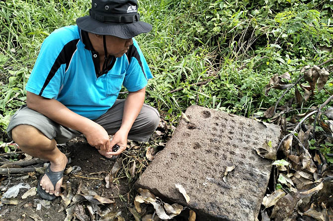 Warga menunjukkan salah satu benda diduga cagar budaya dekat makam di Dusun Tebas, Desa Kepulungan, Gempol. (Rizal Syatori/Radar Bromo)