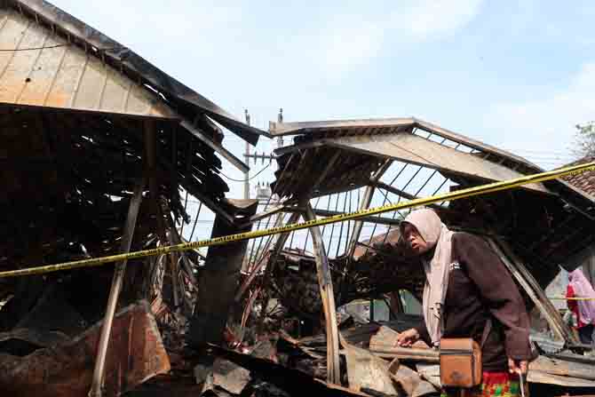 SENGAJA DIBAKAR?: Los yang terbakar di Pasar Gondanglegi, Desa Cangkringmalang, Kecamatan Beji dipasangi police line. Ada dugaan pasar ini sengaja dibakar. (Foto: Mukhamad Zubaidillah/Jawa Pos Radar Bromo)