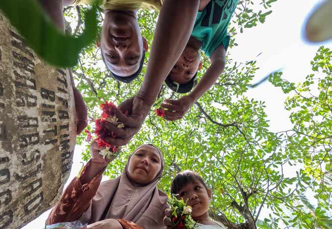 SUDAH TRADISI: Daniel bersama istri dan anaknya menabur bunga di makam ibundanya kemarin di TPU Purutrejo 1. (Foto: M Zubaidillah/Jawa Pos Radar Bromo)
