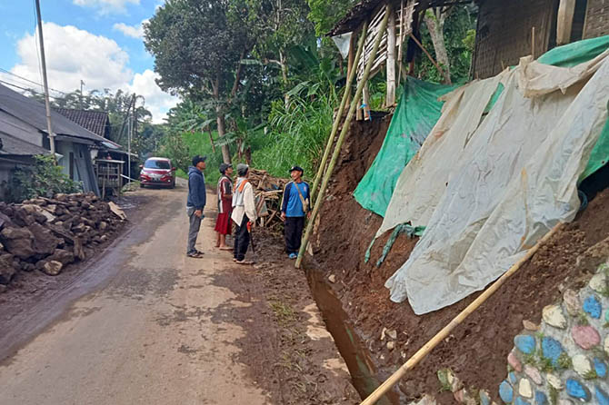 DITUTUP TERPAL: Plengsengan rumah warga di Gerbo, Purwodadi yang tergerus longsor. (Tagana for Radar Bromo)