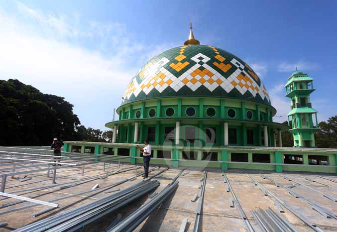 DIGARAP: sejumlah pekerja menggarap pemasangan atap galvalum di atap masjid Raudlatul Jannah, Kota Probolinggo. (Foto: Zainal Arifin/Jawa Pos Radar Bromo)