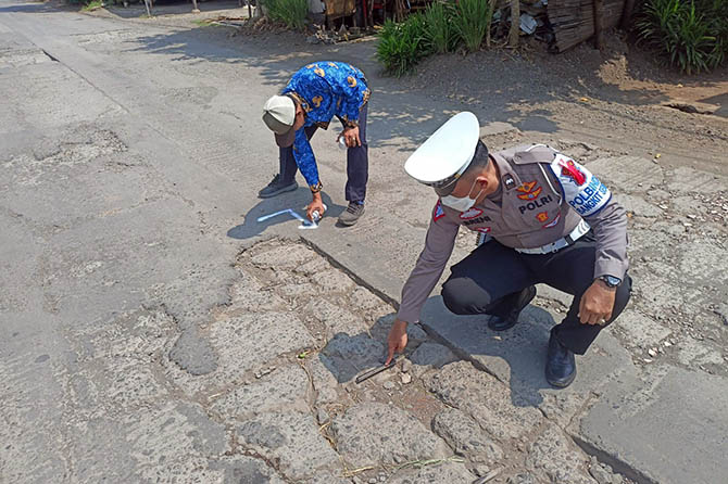 Sejumlah petugas saat menandai ruas jalan yang alami kerusakan. (Istimewa)