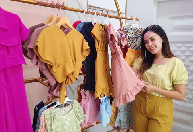 BANYAK BELAJAR: Putri Alvio dengan pakaian anak yang dijualnya. (Foto: Fahrizal Firmani/Jawa Pos Radar Bromo)