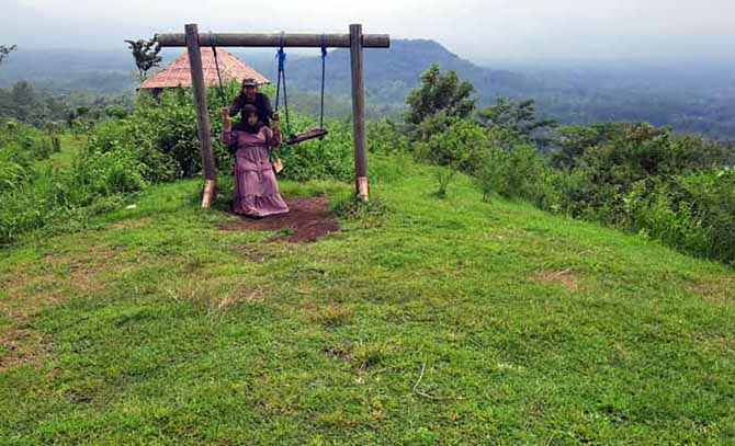 INDAH: Pengunjung menikmati fasilitas ayunan yang berada di wisata Bukit Dami di Desa Tigasan Wetan, Kecamatan Leces. (Foto: Fahrizal Firmani/Jawa Pos Radar Bromo)