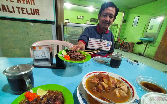 MENGGODA: Adi Putro saat menyajikan menu sate kambing khas Bangil. (Foto: Iwan Andrik/Jawa Pos Radar Bromo)
