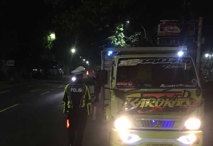 TEGAS: Personel Satlantas menghentikan truk yang melaju di Jalan Juanda, Selasa (12/4) malam. (Foto: Satlantas Polres Pasuruan Kota)