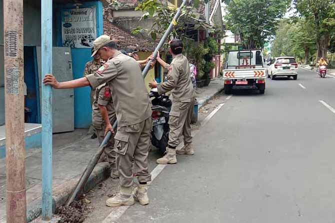DICABUT: Personel Satpol PP mencopot tiang wifi ilegal di kawasan Bugul Kidul, Kamis (30/3) lalu. Penertiban serupa akan dilakukan aparat penegak perda di seluruh sudut Kota Pasuruan. (Foto: Satpol PP Kota Pasuruan for Jawa Pos Radar Bromo)