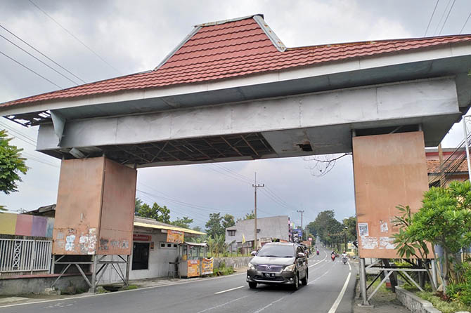 KUSAM: Kondisi gapura akses ke kawasan wisata Tretes yang kondisi atapnya alami kerusakan. (Rizal Syatori/Radar Bromo)