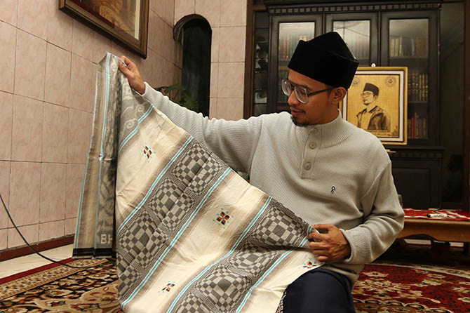 KOLEKSI: Pengasuh Pesantren Darut Tauhid Bangil, Kabupaten Pasuruan, Muhammad Imam Haromain, menunjukkan sejumlah koleksi sarungnya. (M. Zubaidillah/Jawa Pos Radar Bromo)