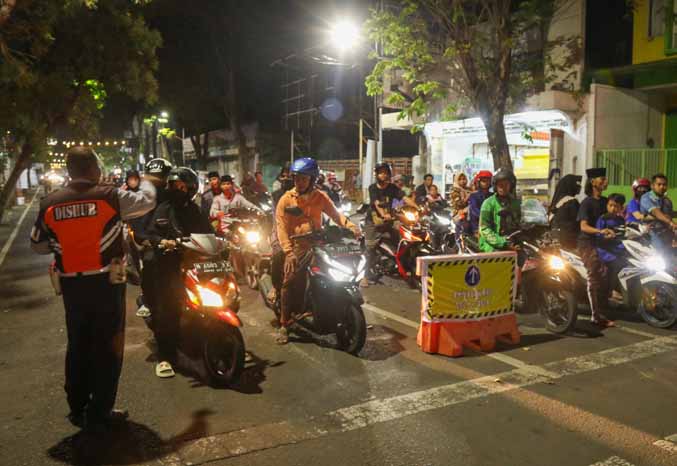 SOSIALISASI: Petugas Dishub memberi pengertian ke pengendara di Jalan KH Wahid Hasyim, Senin (17/4) malam. Jalan ini sebelumnya hanya satu arah, namun untuk sementara diberlakukan dua arah. (Foto: M Zubaidillah/Jawa Pos Radar Bromo)