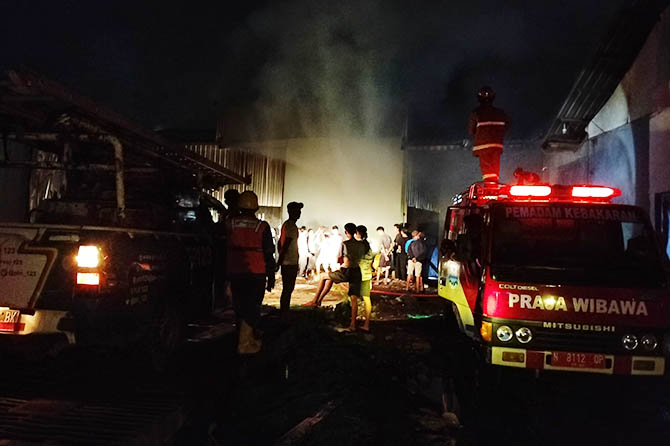 TIGA UNIT: Dua unit mobil damkar dan satu unit mobil supply memadamkan api yang membakar pabrik pengolahan kayu palet di Dusun Nangger, Desa Bulang, Kecamatan Gending. (Achmad Arianto/Radar Bromo)