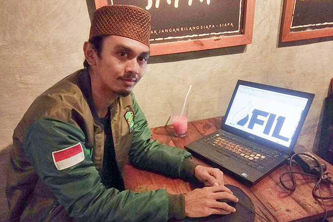 JAGO DESAIN LOGO: Pengasuh Ponpes Alqusyairi, Kecamatan Rejoso, Achmad Mi’yarul Ilmi atau Gus Ilmi menunjukkan salah satu desain logo karyanya. (Muhamad Busthomi/jawa Pos Radar Bromo)