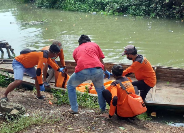 Petugas saat mengevakuasi jenazah korban tenggelam di tambak, Bangil.