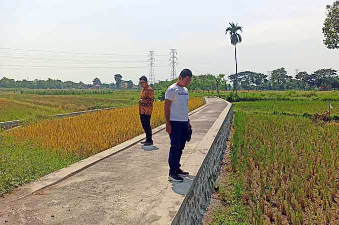 KOKOH: Kades Selogudig Wetan Bagus Budi Prayoga (kanan) mengecek jalan rabat di Dusun Talang. (Foto: Istimewa)
