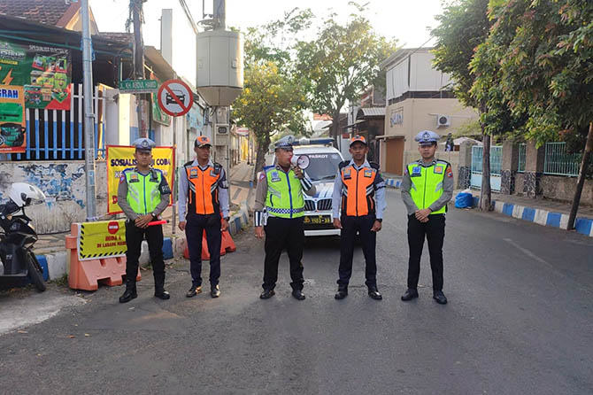 MASIH IMBAUAN: Personel Satlantas Polres Pasuruan Kota di simpang tiga Jalan KH Abdul Hamid dan Gajah Mada saat sosialisasi aturan satu arah. (Foto: Satlantas Polres Pasuruan Kota for Radar Bromo)