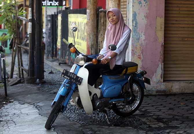 KLASIK: Dewi Ayu Wulandari, tetap pede menggunakan sepeda motor klasik berupa Honda C70. (Zainal Arifin/Jawa Pos Radar Bromo)