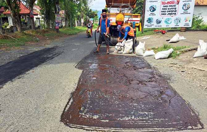 TAMBAL LUBANG: Pengerjaan perbaikan jalan di Kotaanyar beberapa waktu lalu. Pemkab Probolinggo menggelontorkan puluhan miliar tahun ini untuk perbaikan jalan. (Foto: Agus Faiz Musleh/Jawa Pos Radar Bromo)