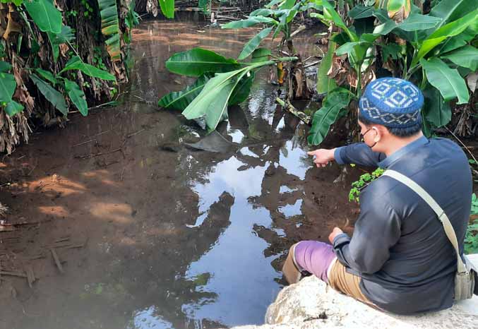 TERUS MENGALIR: Hidayatullah, keturunan Mbah Corah menunjukkan sumber air Curah Grinting yang dulu merupakan ranu. Hingga saat ini masih ada dan airnya dimanfaatkan warga. (Foto: Fahrizal Firmani/Jawa Pos Radar Bromo)
