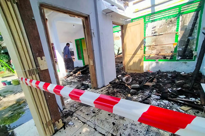 DIDUGA DIPICU KORSLETING: Rumah Hasan dipasang garis usai terbakar, Selasa (30/5). (Iwan Andrik/Radar Bromo)