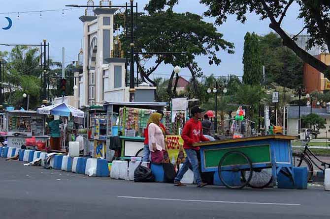 MENGAIS REZEKI: Sejumlah PKL di sekitar Alun-alun Kota Pasuruan bersiap jualan. Pemkot Pasuruan terus melakukan penataan terhadap mereka. (Foto: Mokhamad Zubaidilah/Jawa Pos Radar Bromo)