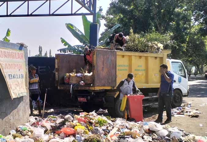 SETIAP HARI: Petugas mengangkut sampah di TPS Kraksaan. (Foto: Foto: dok Jawa Pos Radar Bromo)