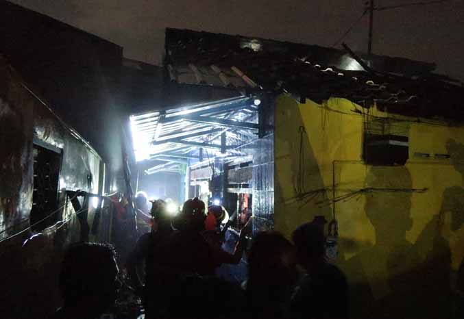PADAM: Petugas Damkar Kota Pasuruan berhasil memadamkam api yang membakar tiga rumah di Jalan Irian Jaya dalam waktu satu jam. Kerugian ditaksir mencapai Rp 200 juta akibat kebakaran itu. (Foto: M. Zubaidillah/Jawa Pos Radar Bromo)