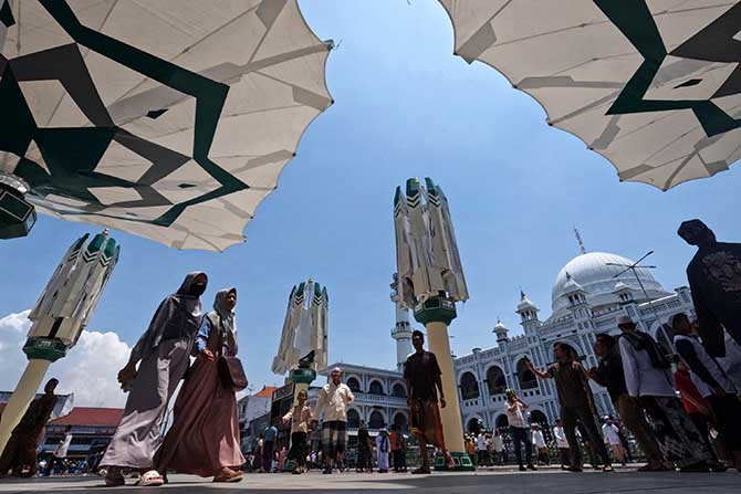 JADI JUJUKAN: Pengunjung berada di sekitar payun hidrolik di depan masjid Jamik Al Anwar saat pagi. Pemkot Pasuruan berencana membangun masjid bernuansa Makkah. (Foto: M Zubaidillah/Jawa Pos Radar Bromo)